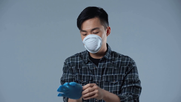 asiatischer Mann mit medizinischer Maske isoliert auf grau  - Filmmaterial, Video