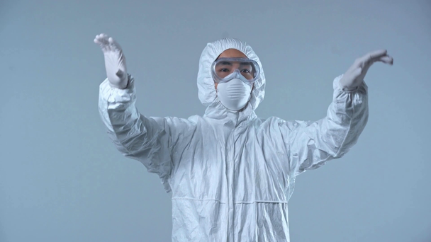 asiático científico en protector traje gesto aislado en gris
  - Imágenes, Vídeo