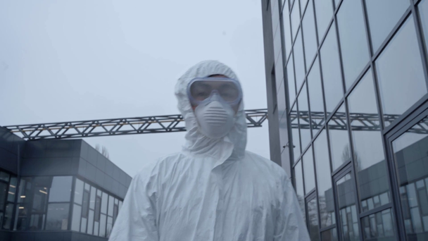 asian scientist in protective suit and mask walking outside - Filmati, video