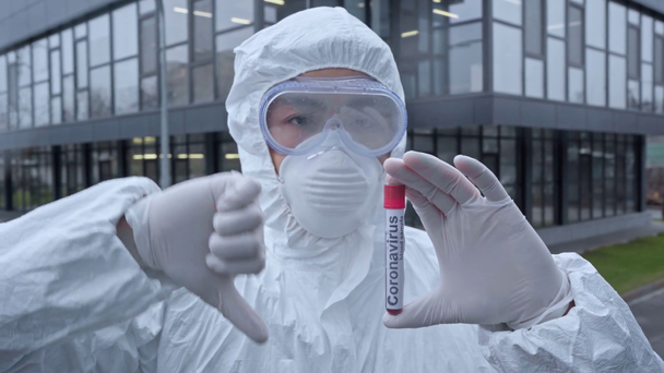азіатський вчений тримає зразок із запалюванням коронавірусу і показує великий палець вниз
 - Кадри, відео