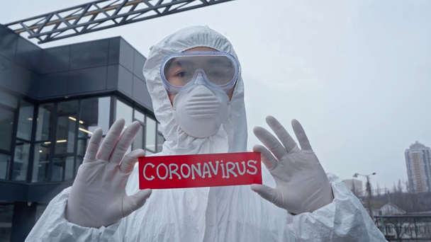 Ασιάτης επιστήμονας κρατώντας χαρτί με γράμματα coronavirus  - Πλάνα, βίντεο