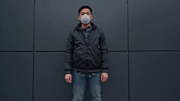 asian man in protective mask standing near building  - Footage, Video