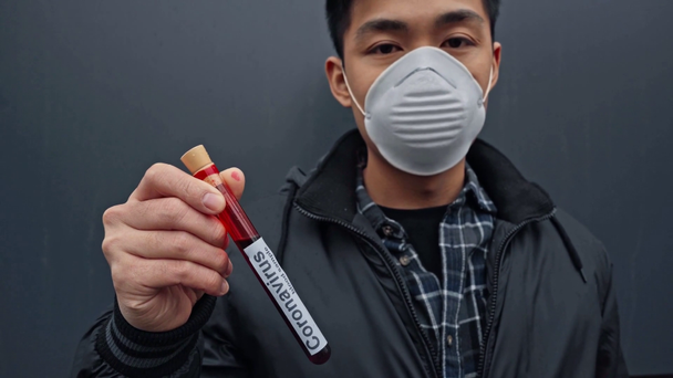 ázsiai férfi orvosi maszkban minta a szürkén koronavírus felirattal  - Felvétel, videó