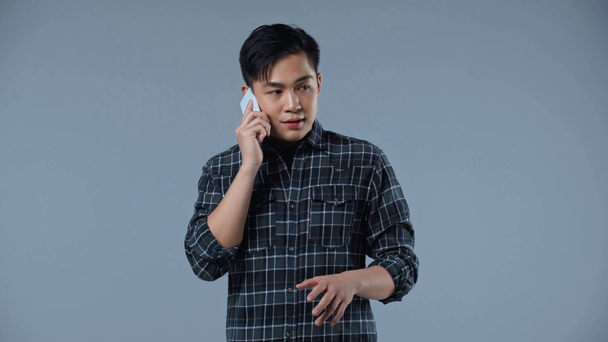 asiatico uomo parlando su smartphone isolato su grigio
  - Filmati, video