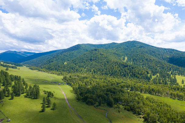 Aerial landscape with mountains, green trees, field, road and ri - Foto, afbeelding