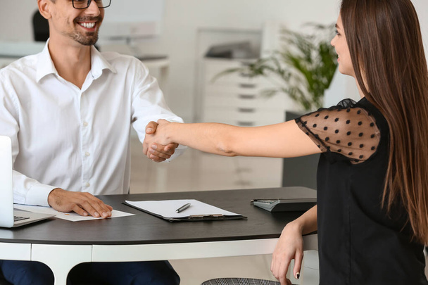 Bank manager shaking hands with woman in office - Photo, Image