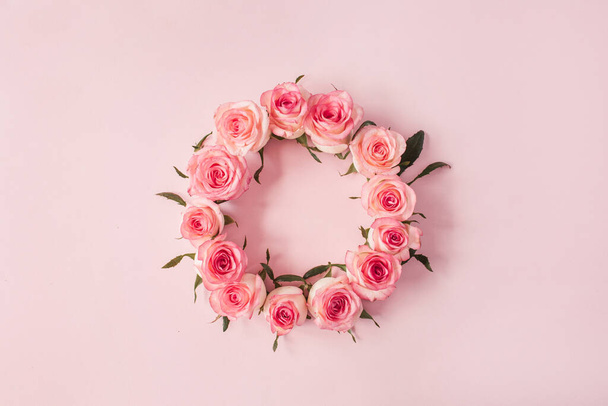 Round frame border of pink rose flower buds on pink background. Mockup blank copy space. Flat lay, top view floral composition. - Photo, Image