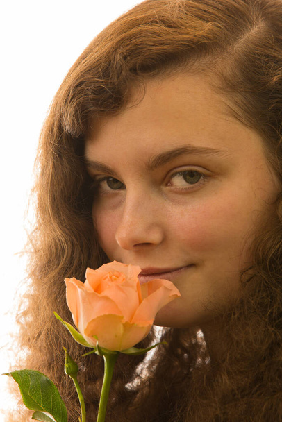 Nuori kaunis nainen pitää ruusua kädessään.
 - Valokuva, kuva