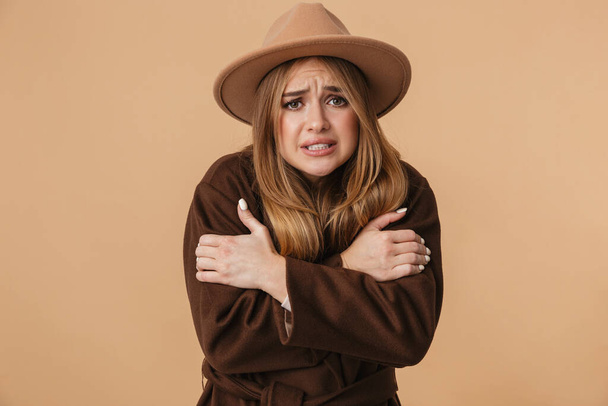 Image of young girl wearing hat and coat trembling and feeling c - Foto, Bild
