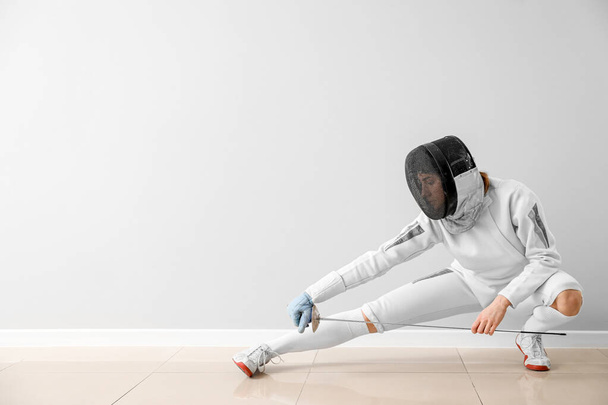 Young female fencer against white wall - Photo, Image