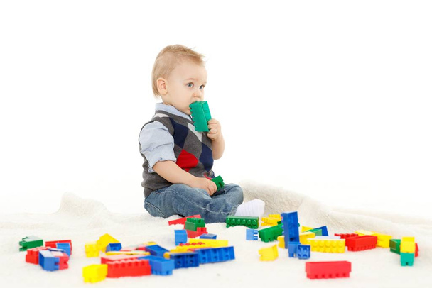 Sweet small boy  with toys on a white background. - Фото, зображення