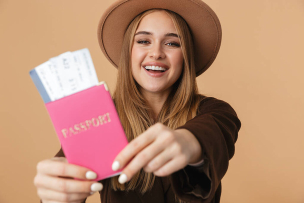 Image of optimistic girl wearing hat holding passport and travel - Foto, imagen