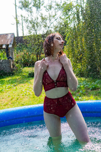 nude woman, wet red hair, nature, swimming pool - Foto, afbeelding