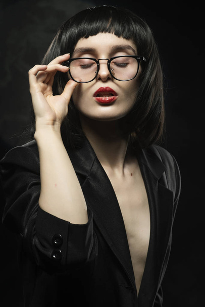 Beautiful braless slim girl with red lips, wearing a unbuttoned  - Foto, afbeelding