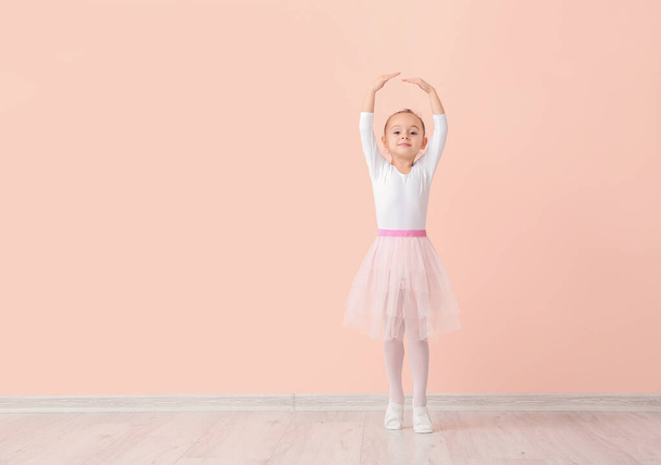 Cute little ballerina against color wall - Fotó, kép