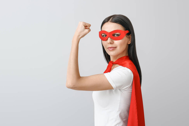 Woman in superhero costume on grey background. Concept of feminism - Photo, Image