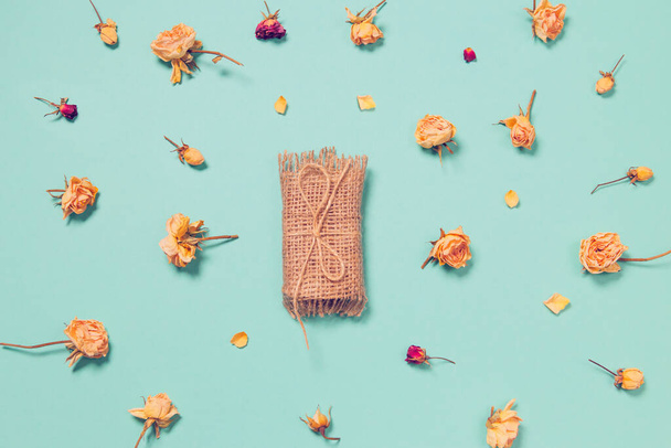 Natural soap with dried rose buds as a decoration on colorful ba - Photo, Image