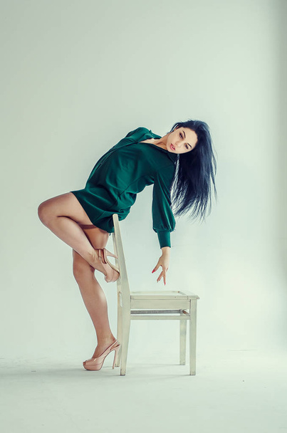 Semi-nude beautiful girl posing on a chair in a classic suit. - Foto, afbeelding