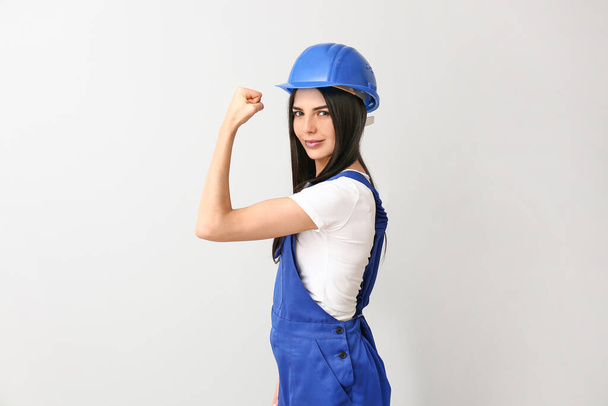 Female worker against light background. Concept of feminism - Photo, Image