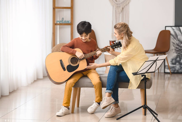 privater Musiklehrer gibt kleinem Jungen zu Hause Gitarrenunterricht - Foto, Bild
