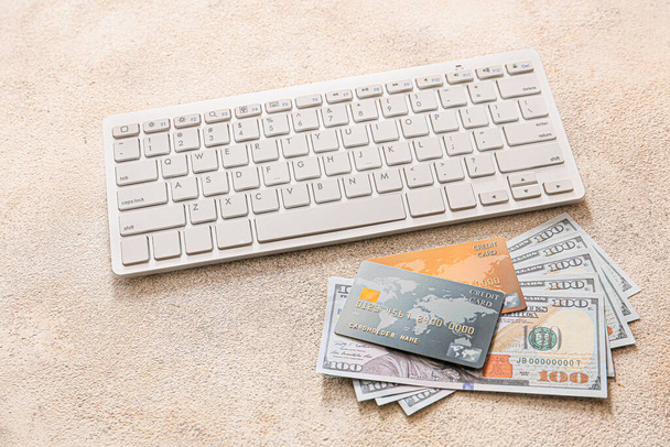 Hitelkártyák pénzzel és számítógépes billentyűzeten szürke alapon. Az online banki tevékenység fogalma - Fotó, kép