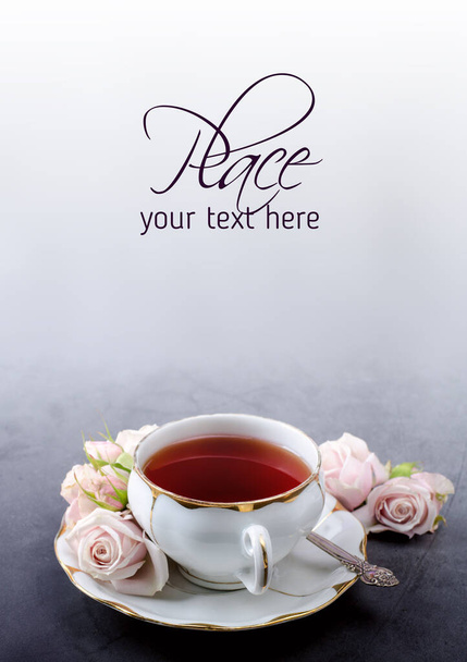 Banner ώρα τσαγιού με vintage λευκό φλιτζάνι τσάι πορσελάνη, απαλό ροζ τριαντάφυλλα σε σκούρο γκρι φόντο. - Φωτογραφία, εικόνα