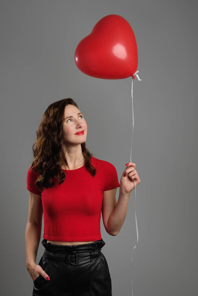 schöne emotionale Brünette Mädchen mit roten Luftballon - Foto, Bild