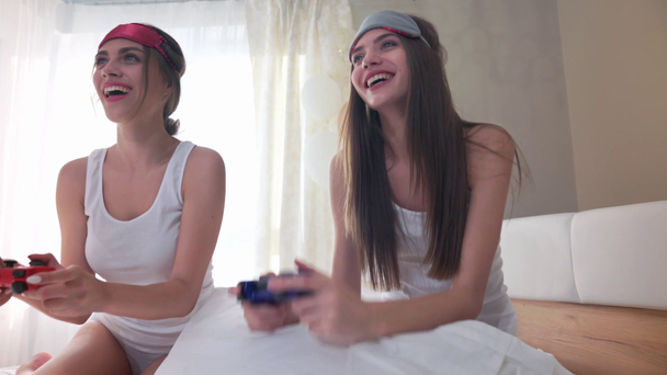 Vrolijke lachende vrouwen die videospelletjes spelen met joysticks - Video