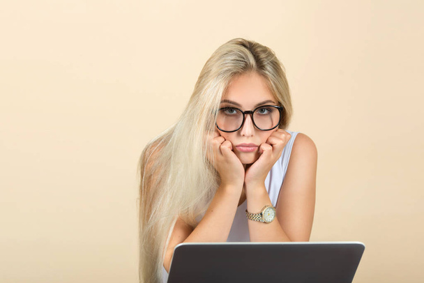 ノートパソコンを背景に眼鏡をかけた美しい若い女性が - 写真・画像