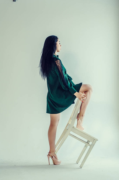 Semi-nude beautiful girl posing on a chair in a classic suit. - Foto, Imagen