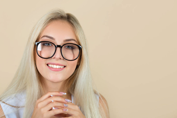 beautiful young woman in glasses on a beige background - Photo, Image