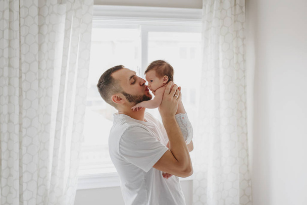 glücklicher kaukasischer Vater küsst neugeborenes Baby. männlicher Mann Elternteil - Foto, Bild