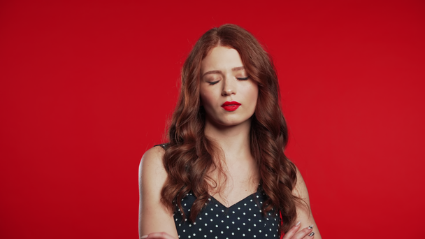 Kıvırcık kızıl saçlı, mutsuz ve mutsuz genç bir kadın. Kızın stüdyo resmi, fikir ayrılığı ve hayal kırıklığı jesti gibi başını sallıyor. - Video, Çekim