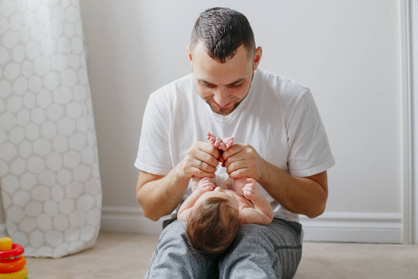 Gelukkige blanke vader die pasgeboren baby op schoot houdt. Man p - Foto, afbeelding