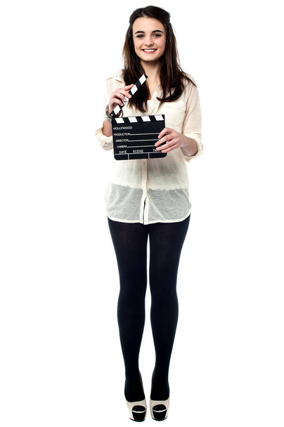 Trendy young girl posing with a clapperboard isolated on white. - 写真・画像