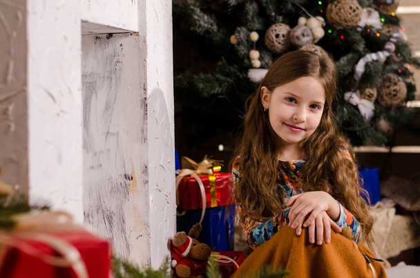 Hermosa chica pequeña posando en estudio decorado en Navidad  - Foto, Imagen
