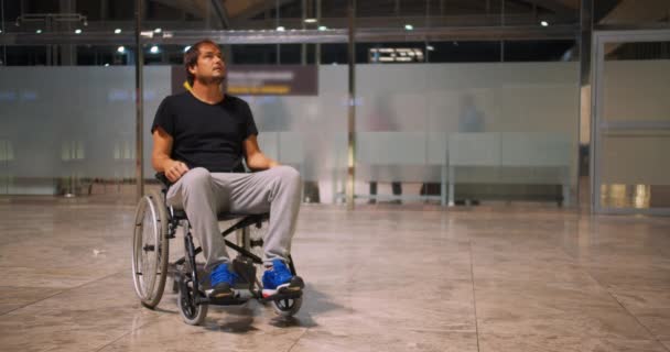 Инвалидный молодой человек в инвалидной коляске в аэропорту
. - Кадры, видео
