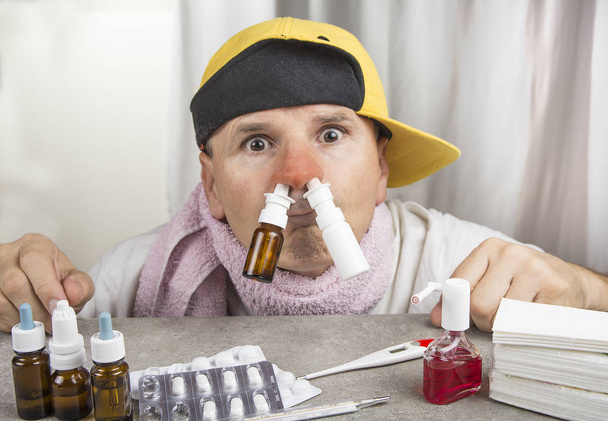 Zimna koncepcja. Chory człowiek z grypą przyjmujący aerozol do nosa. - Zdjęcie, obraz