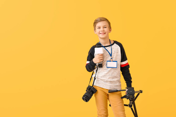 Little journalist with microphone and camera on color background - 写真・画像