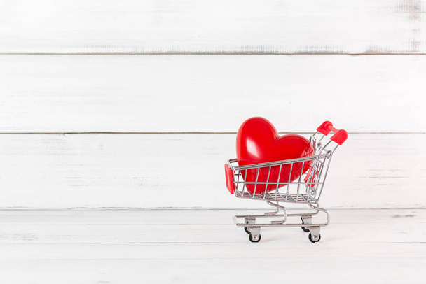Red Heart w wózku Shopping Koszyk na białym tle drewna.  - Zdjęcie, obraz