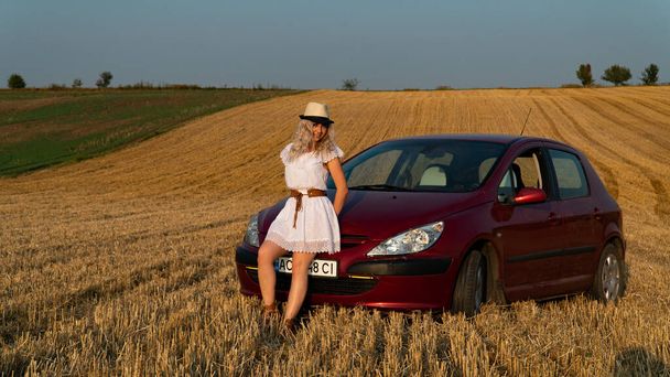 Bella donna bionda sexy, auto rossa, campo
 - Foto, immagini