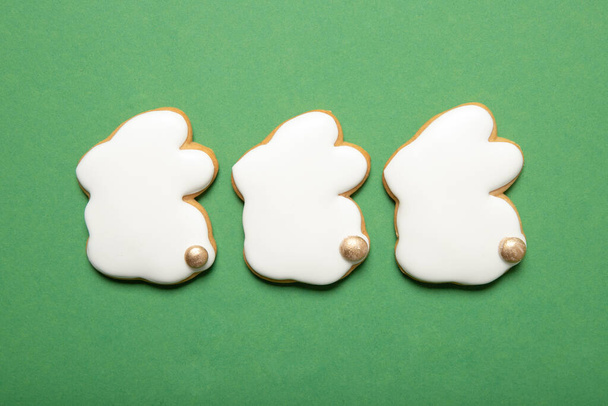 Easter cookies on a green background. Place for text. In the shape of a rabbit. - Фото, изображение
