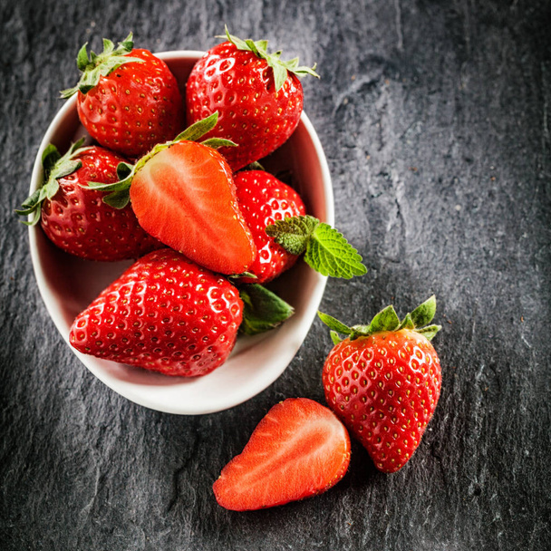 Fresh new image of strawberries on a slate background in square format with copyspace. - Foto, afbeelding