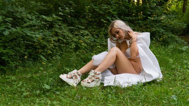 Beautiful sexy blonde woman, the image of a nun in a white raincoat - 写真・画像