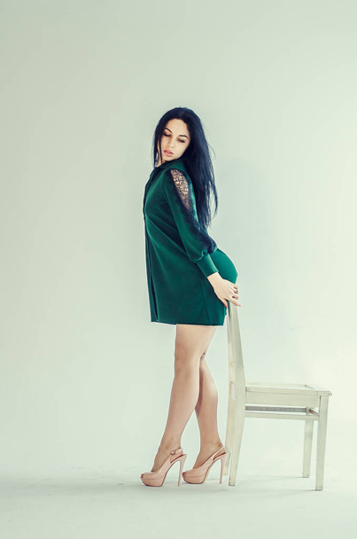 Semi-nude beautiful girl posing on a chair in a classic suit. - 写真・画像