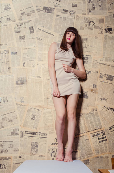 beautiful brunette girl in short beige dress posing in studio  - Fotoğraf, Görsel