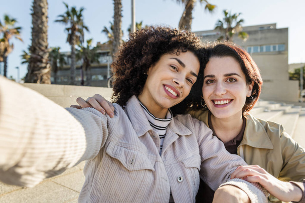 selfie of a multiracial couple of girls smiling - Φωτογραφία, εικόνα