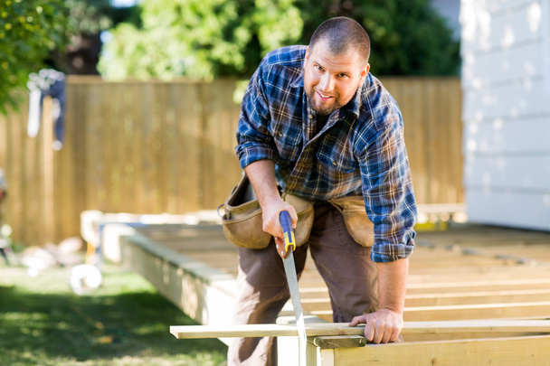Manual Worker Sawing Wood At Construction Site - Foto, Imagem