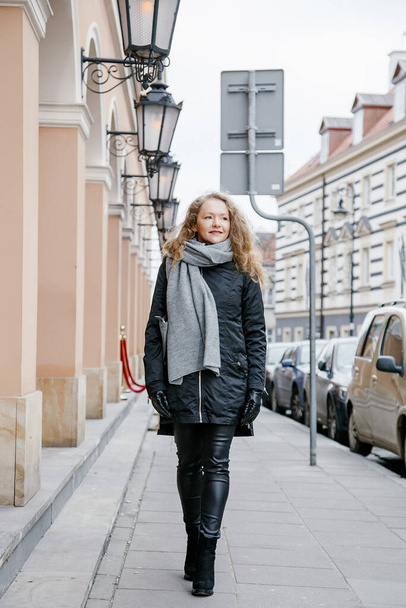 travel the old city. a young woman travels. market square in warsaw. curly girl walks through the streets of the city. - Valokuva, kuva