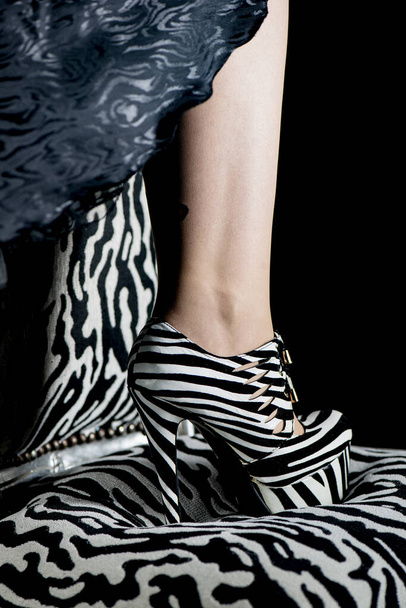 young woman with zebra high heels and chair in zebra pattern - Фото, зображення